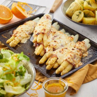 Gegratineerde asperges met ham, nieuwe aardappels & krul andijviesla met sinaasappeldressing